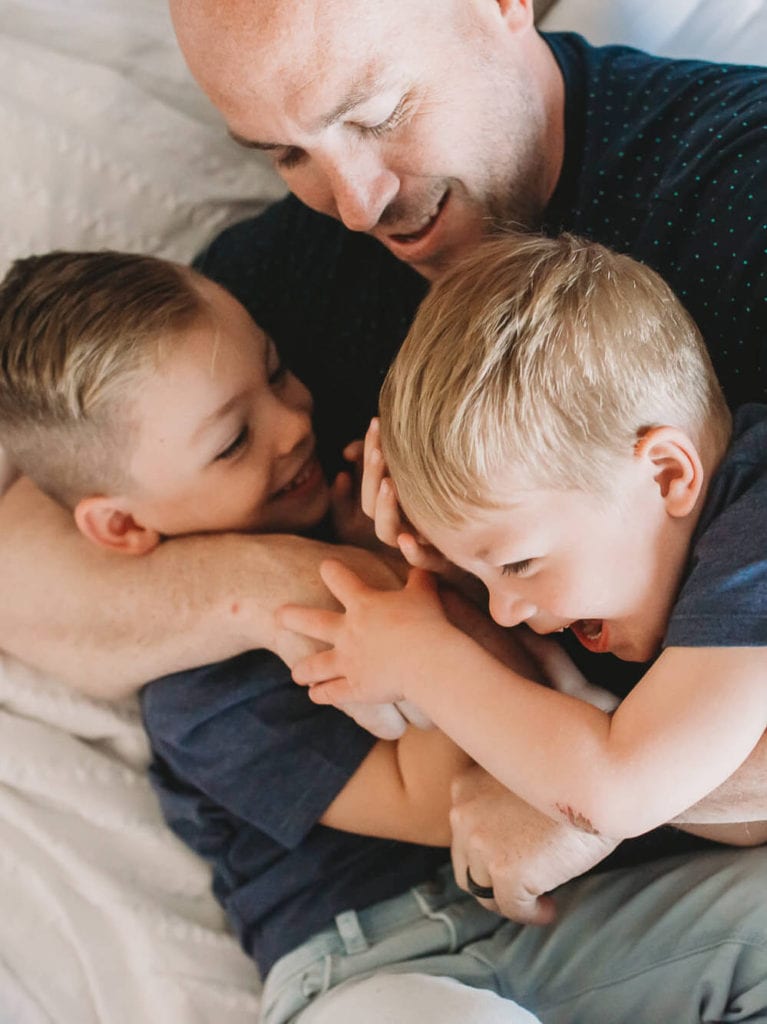 Vancouver Family Photographer shows dad hugging boys