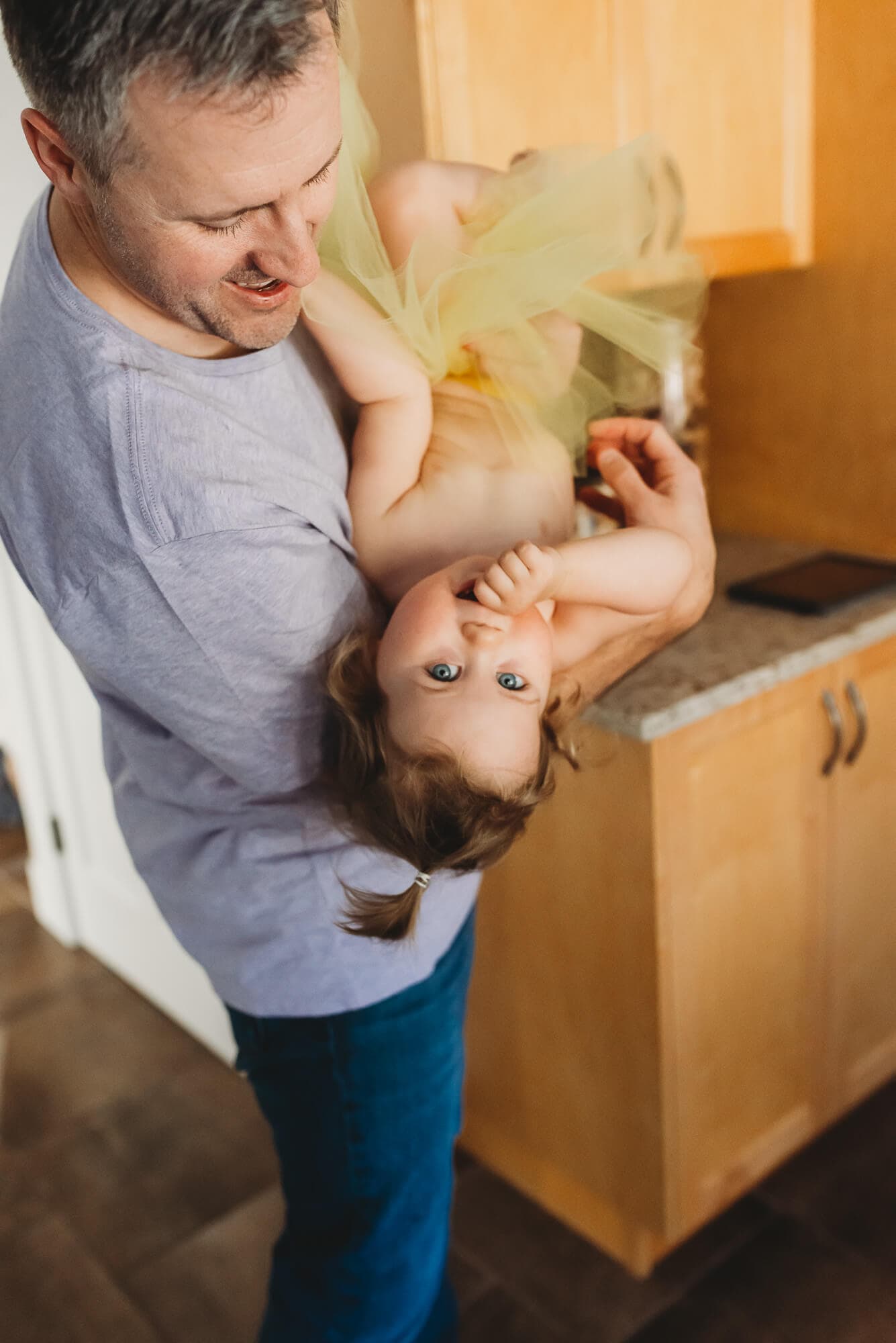 dad carries his daughter upside down