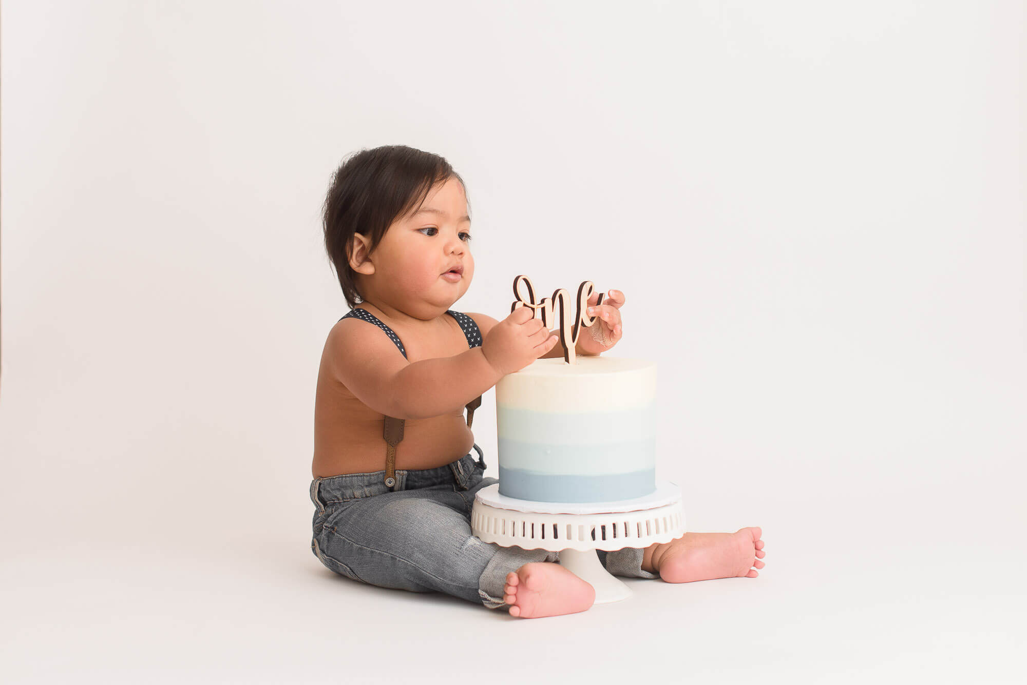 one-year old boy celebrates his cake smash photo session