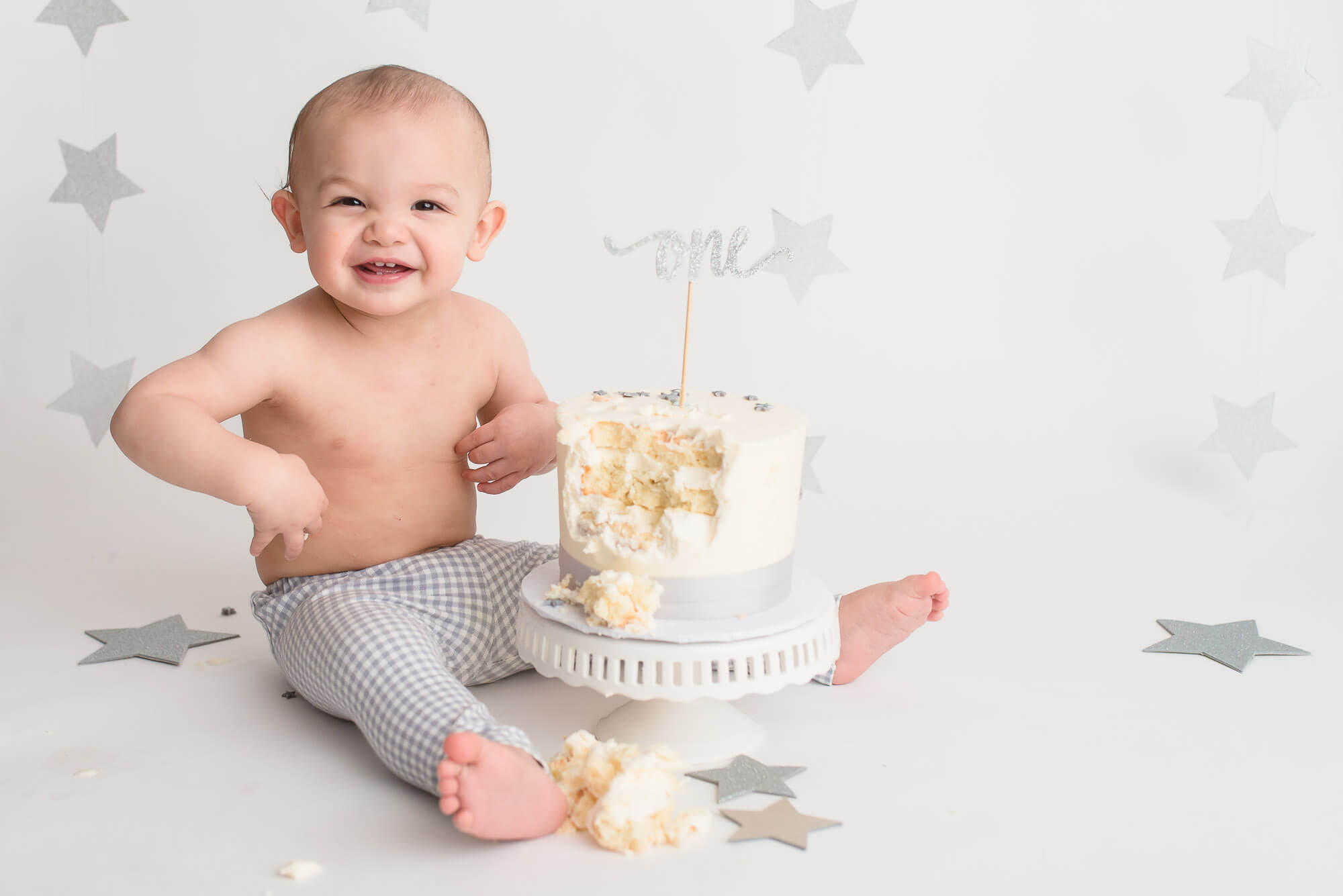 boy laughing with cake during cake smash photography session in Vancouver BC