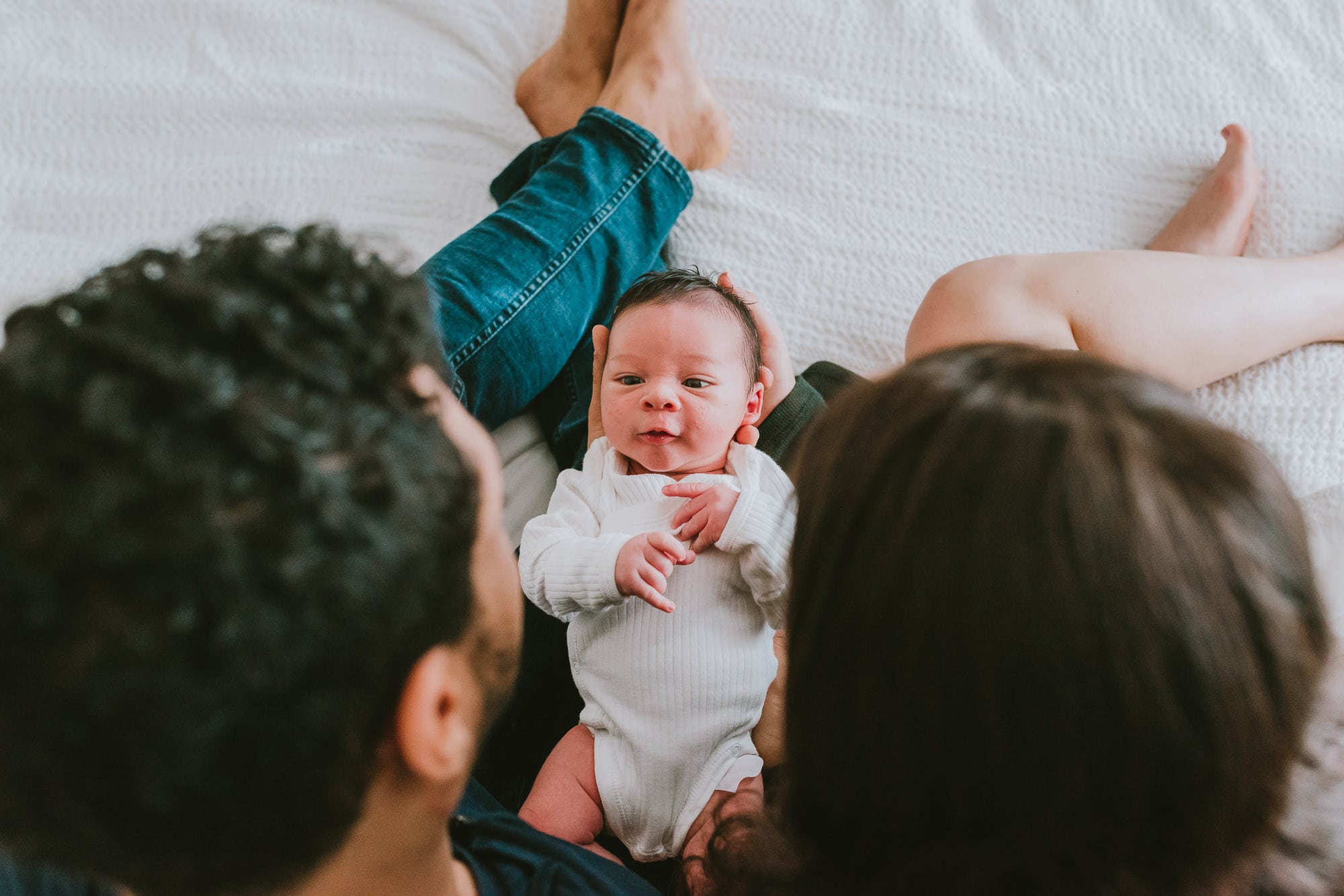 newborn looks at parents captured by vancouver newborn photographer