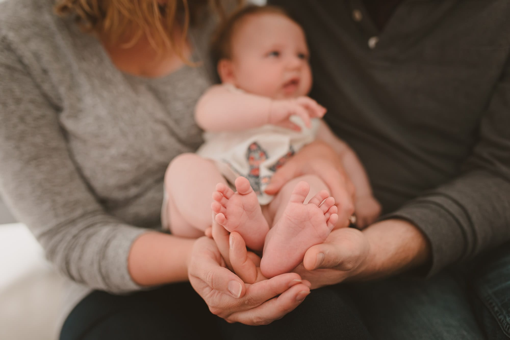 Vancouver Family Photographer focuses on baby feet held by couple