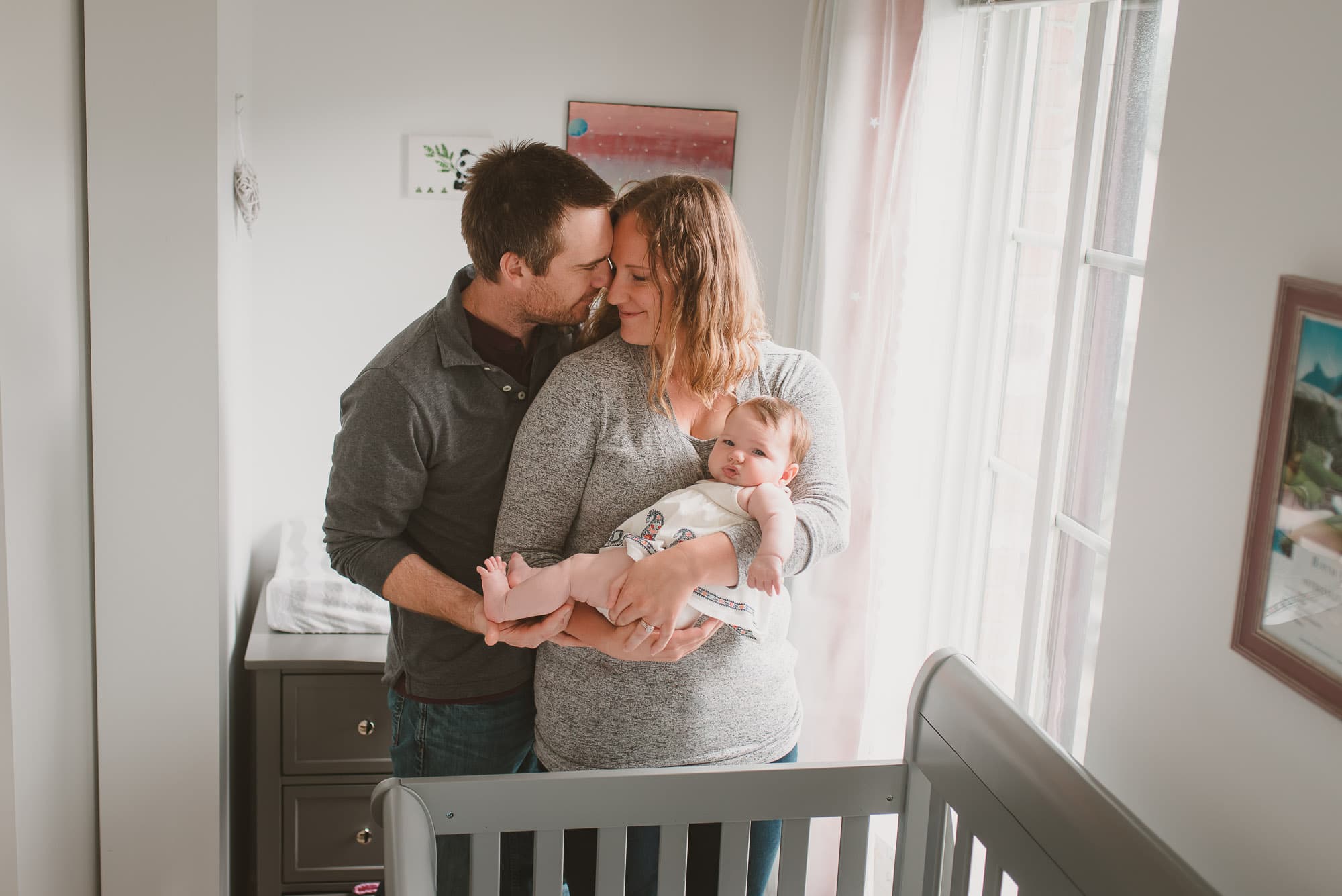 Couple embrace in nursery with Vancouver Family Photographer
