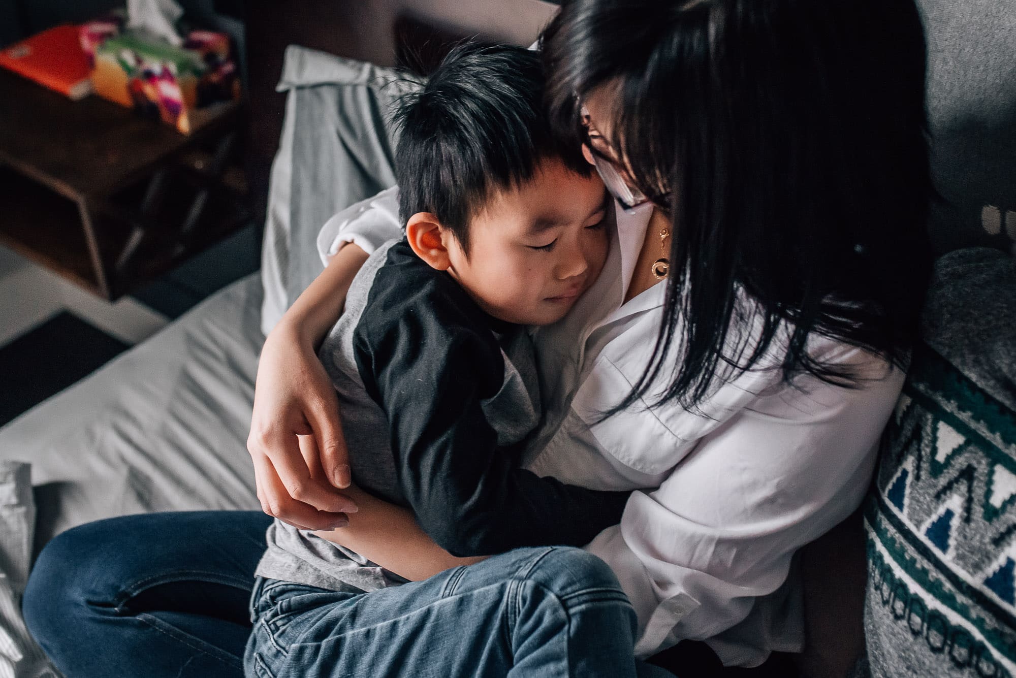 mom hugging boy in in-home family photo shoot