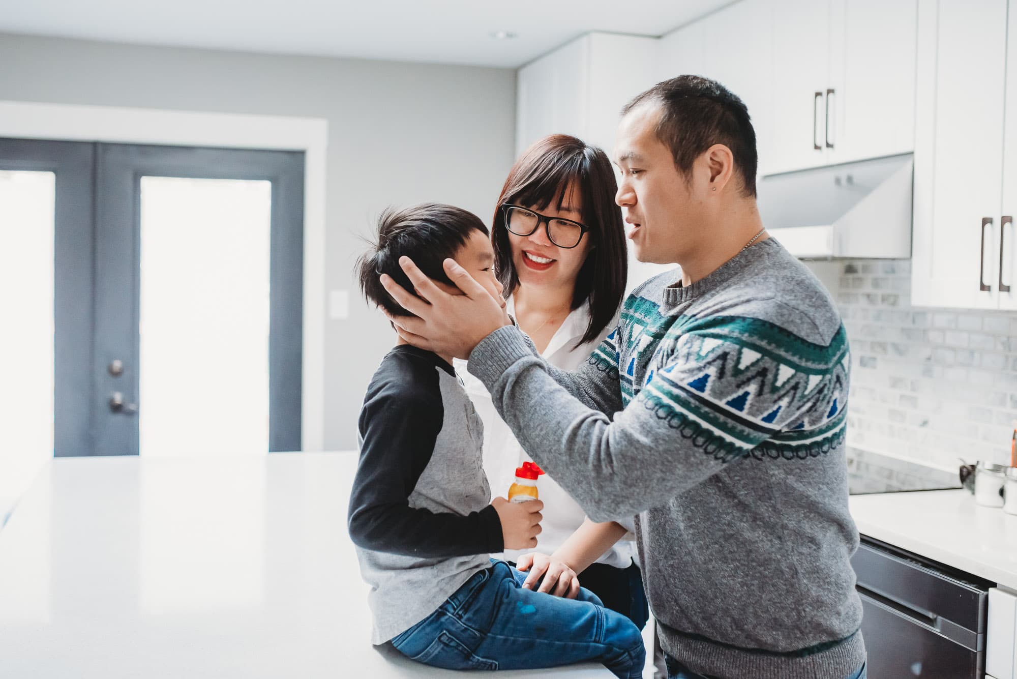 dad hugs son on kitchen counter