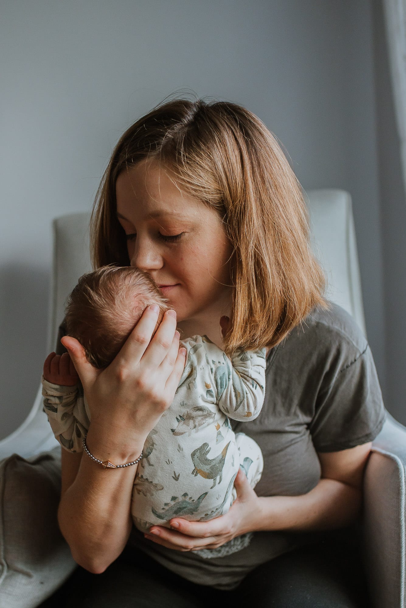 mom kissing newborn in photo session