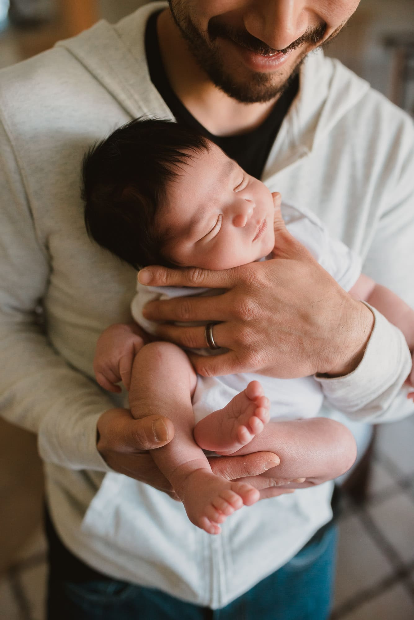 coquitlam newborn photographer captured newborn baby cradled in dad's hands