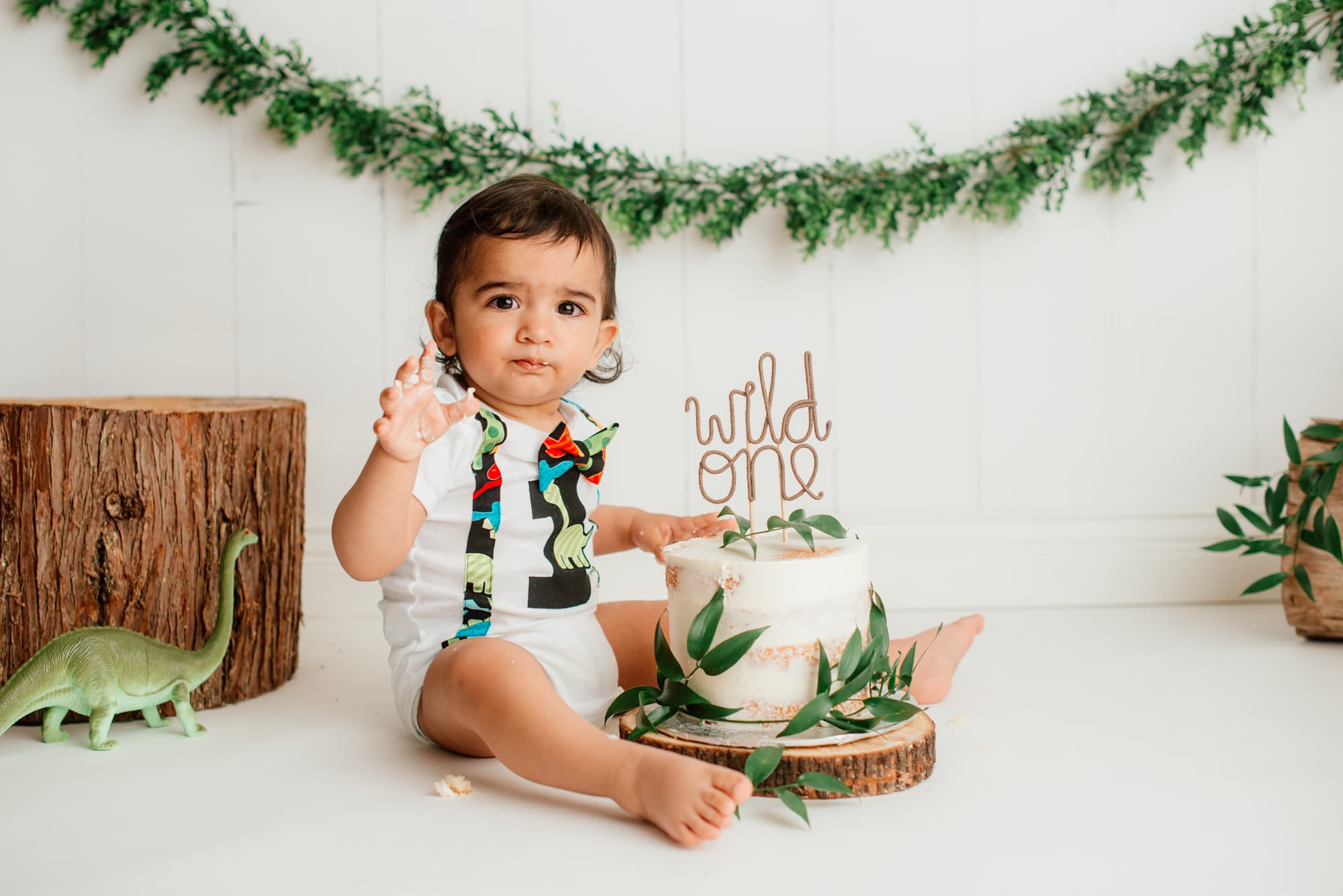 Cake Smash with a Dinosaurs and Wild One theme in a white Vancouver studio.
