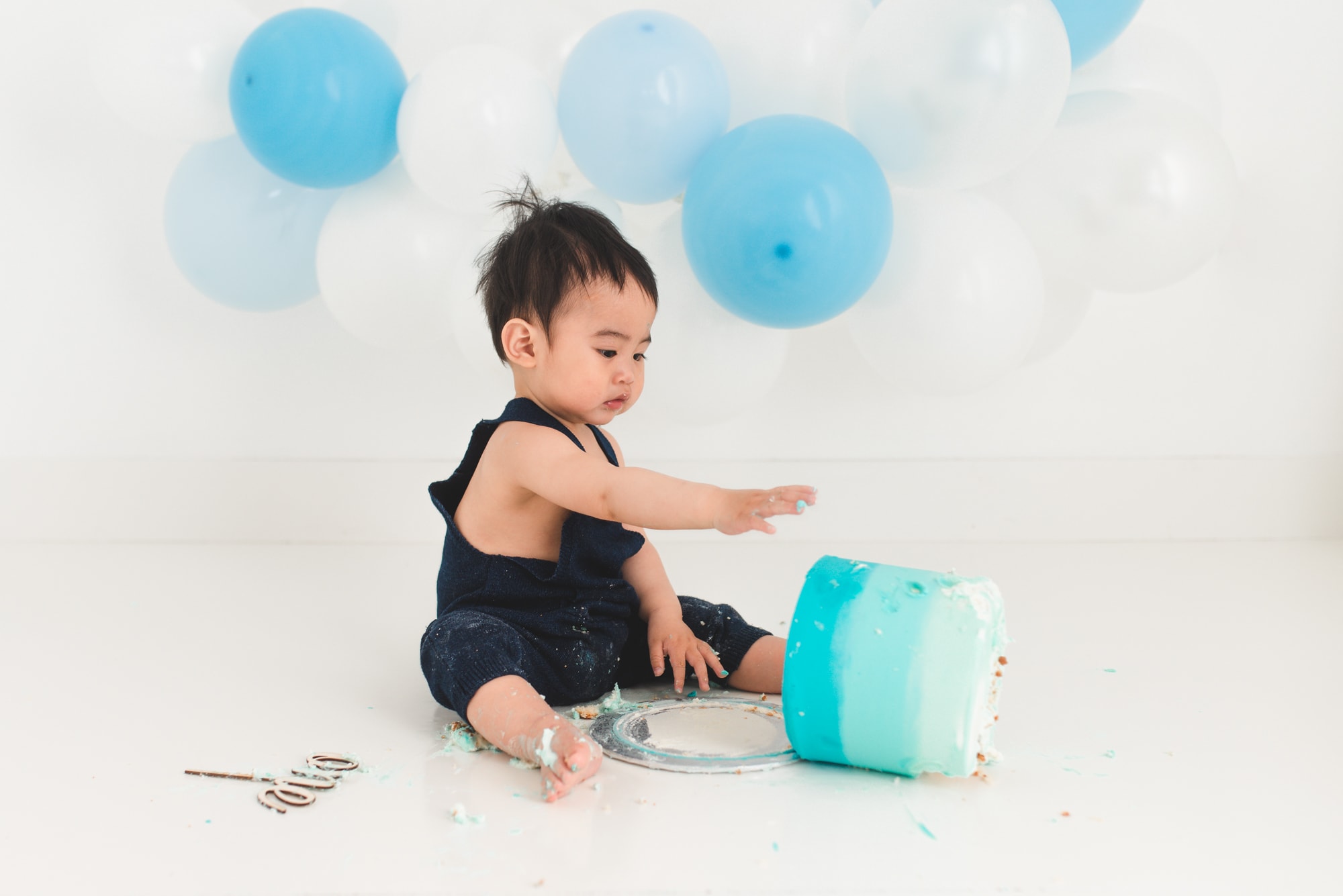 Funny moment when boy pushes his cake over at his first year cake smash celebration.