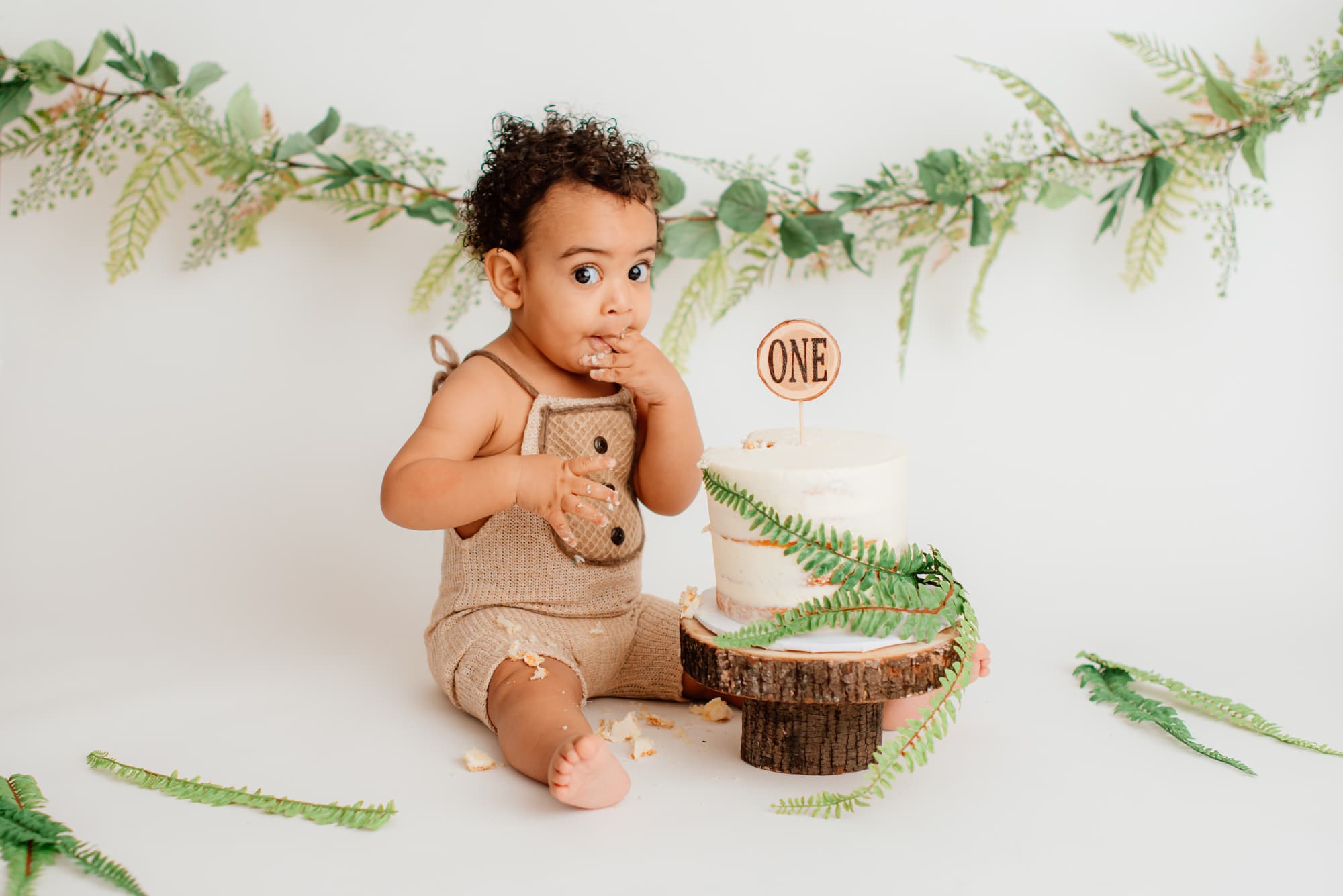 Coquitlam cake smash photography shows boy with ferns at milestone session