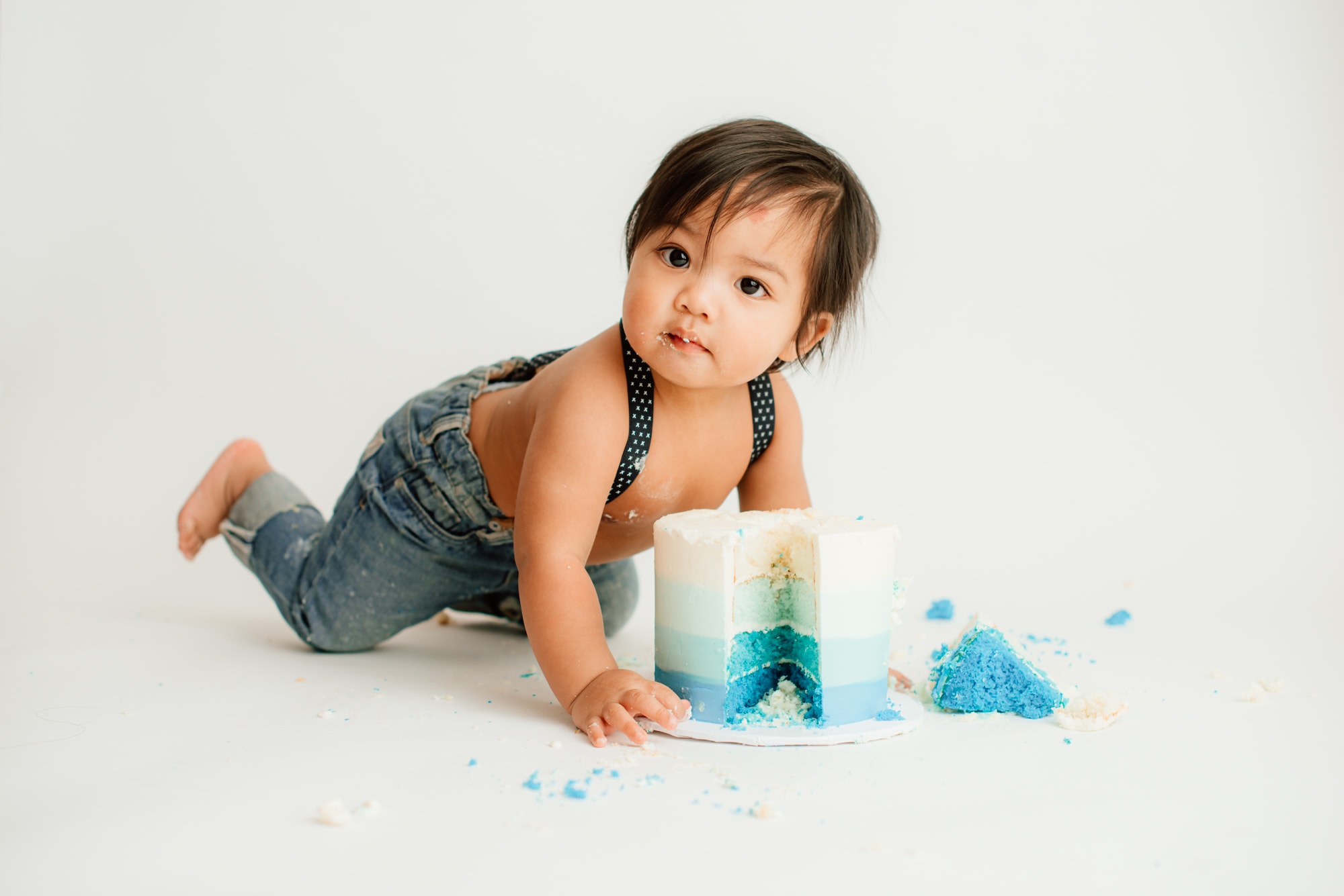 Filipino baby boy crawls towards blue ombre cake in simple cake smash session.