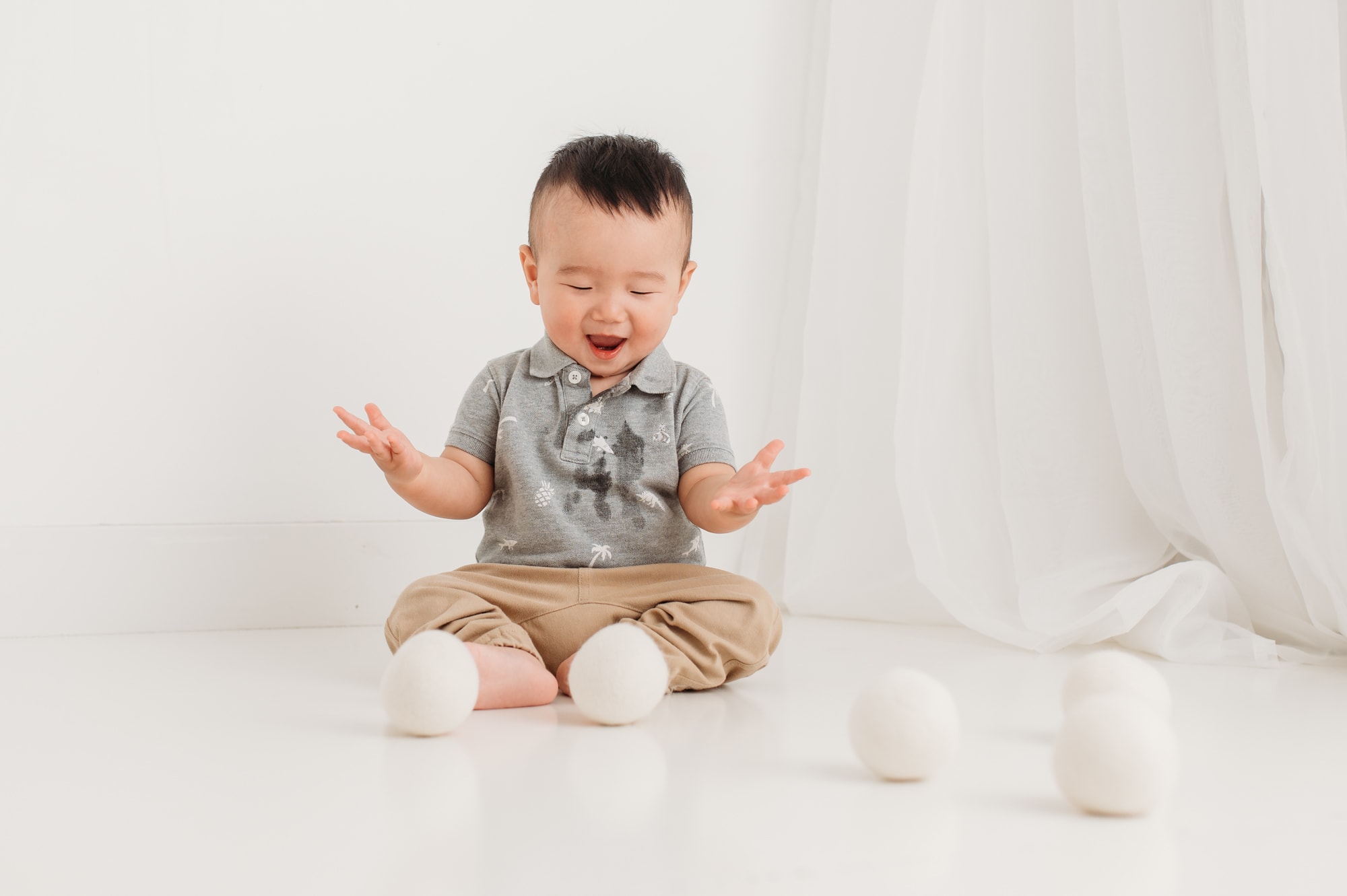 Boy plays with wool balls to celebrate his first birthday photo session in Vancouver.