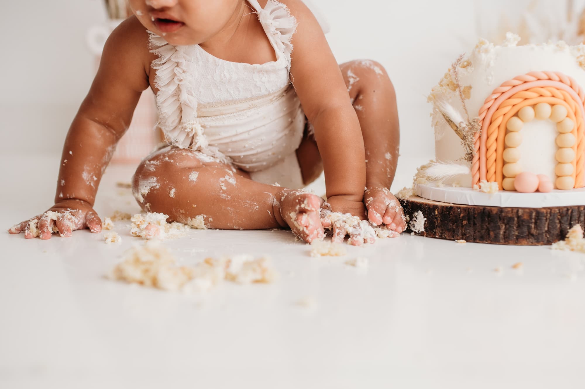 Messy details of little baby feet during cake smash.