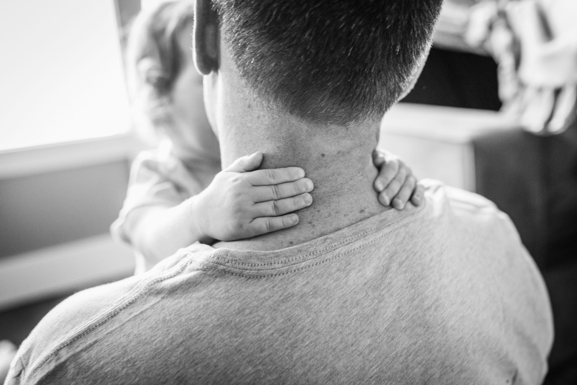 little toddler hands hugging dad's neck