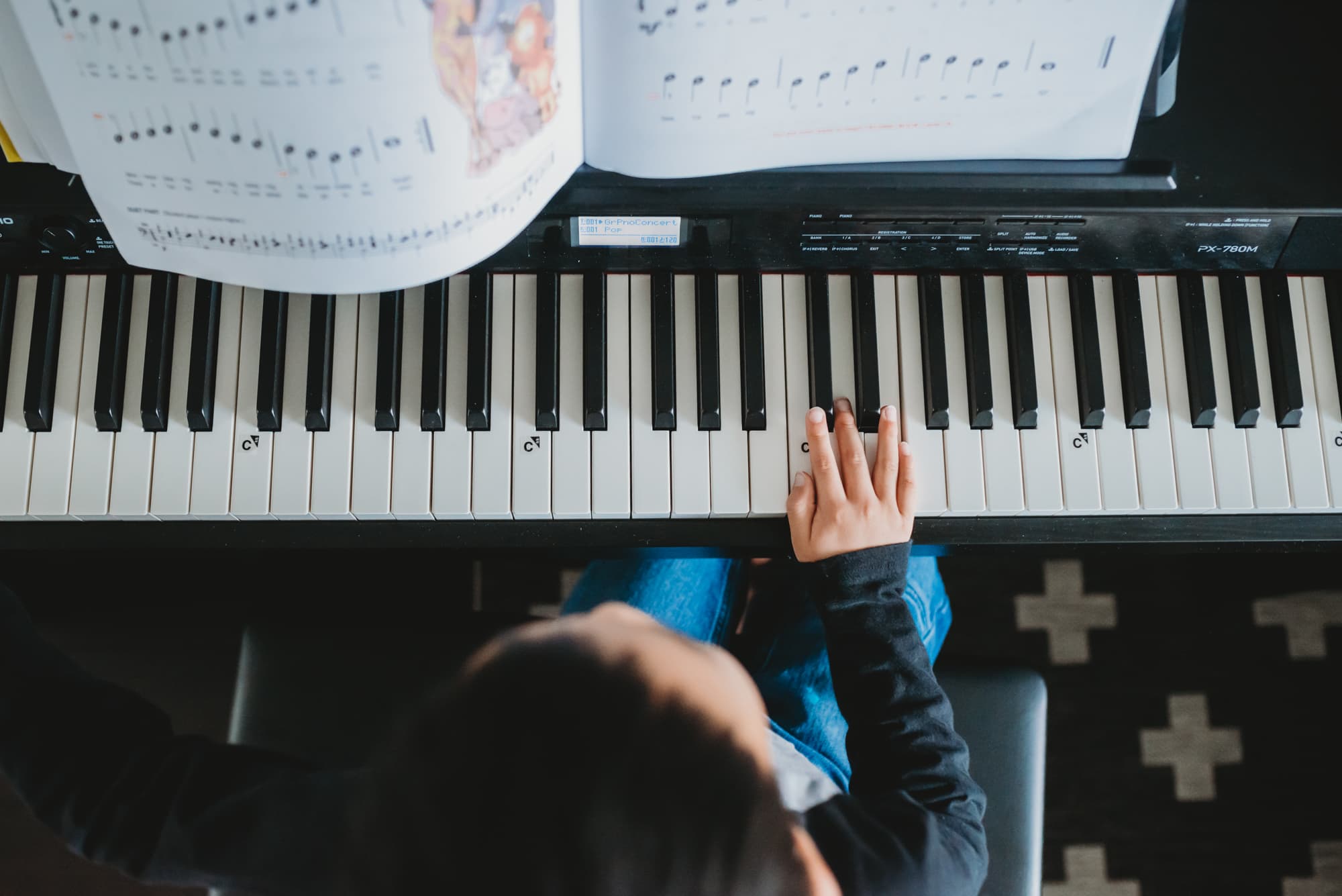 overhead view of boy playing piano during lifestyle in-home family session