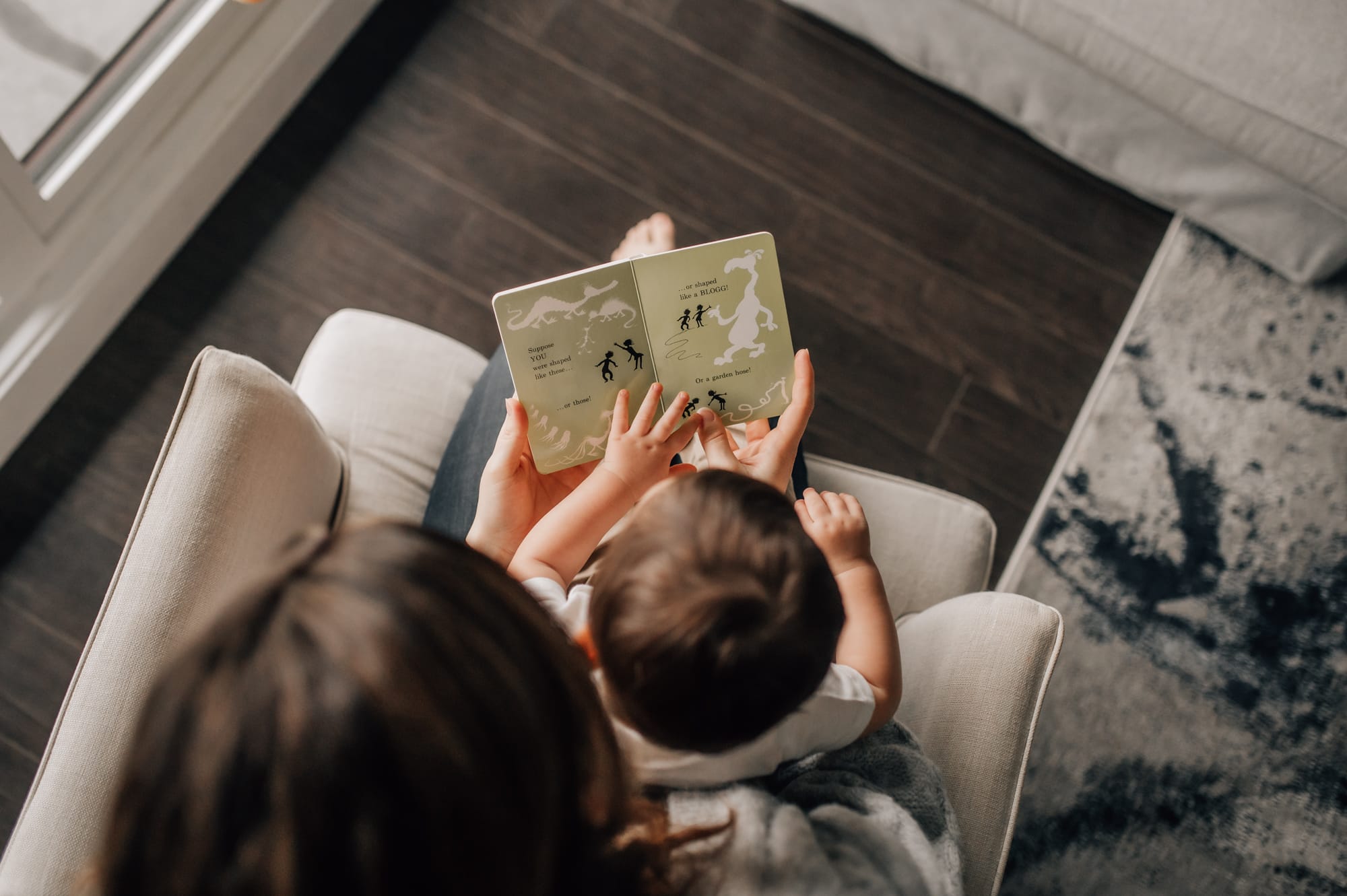 Overhead image of parent and child reading a board book.