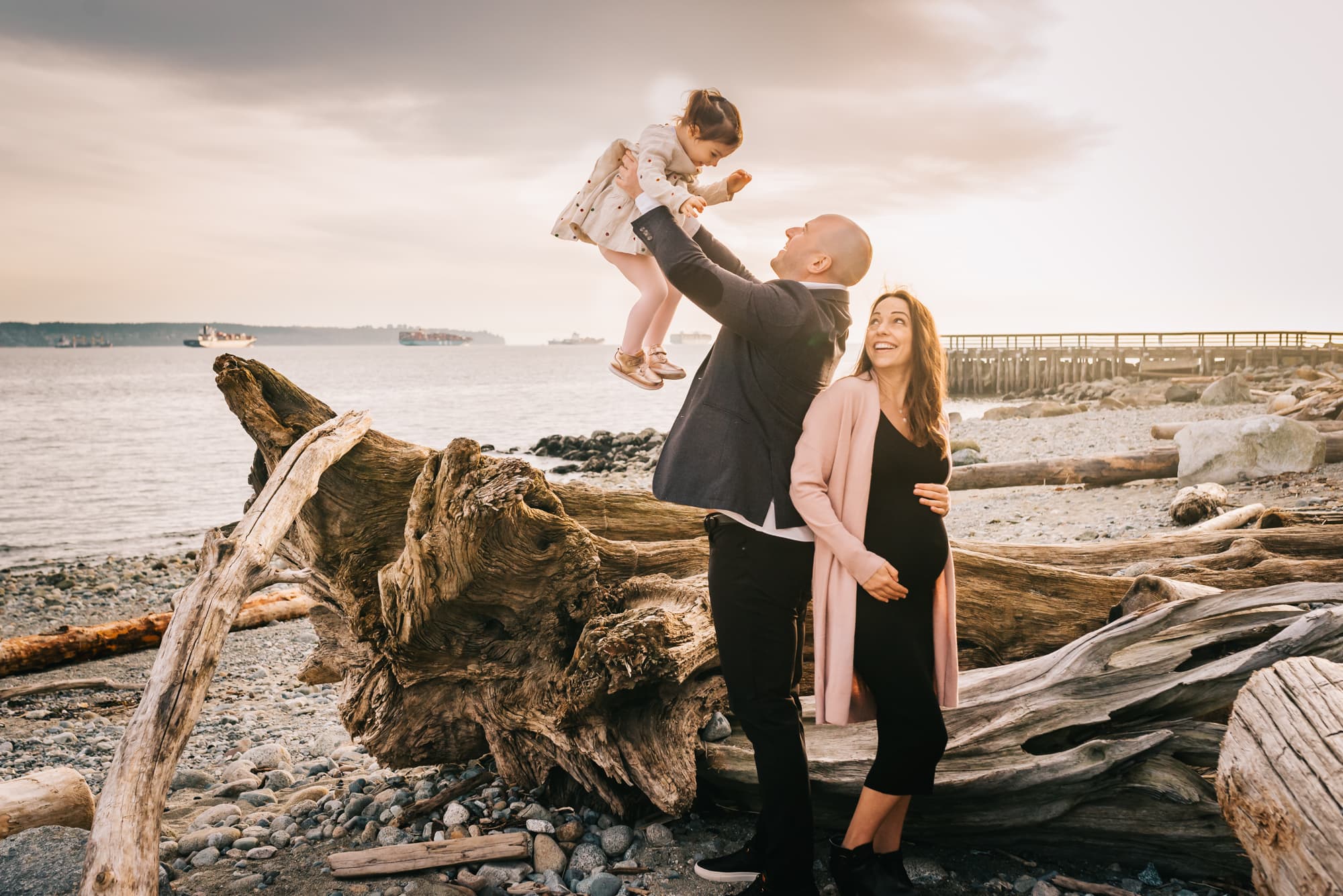 dad lifting girl into air at west vancouver beach family session
