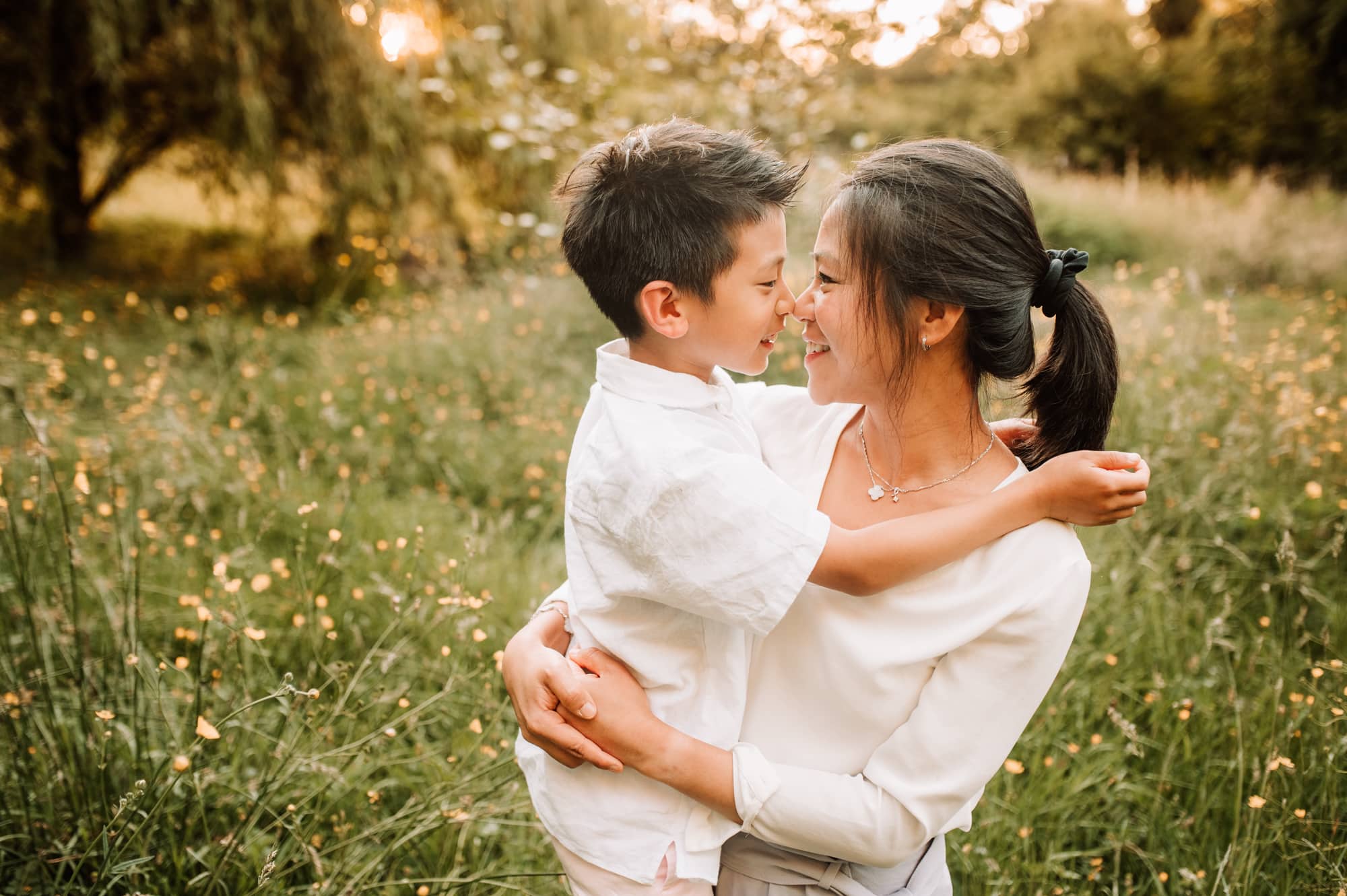Mom and her son share a nose kiss while being photographed in a meadow by a Vancouver family photographer.