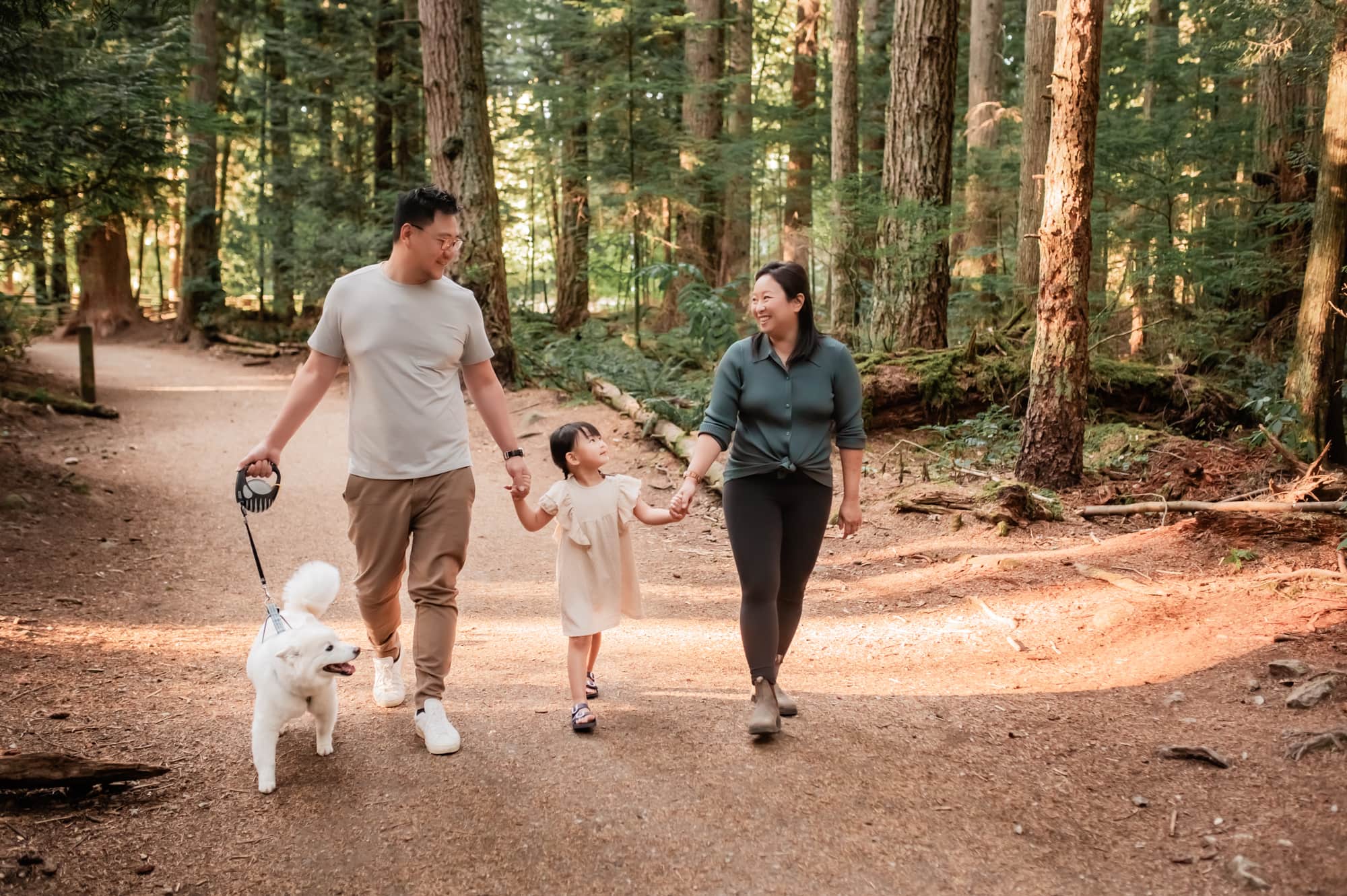 Pacific Spirit Park family photo session with family and their dog walking in the forest.
