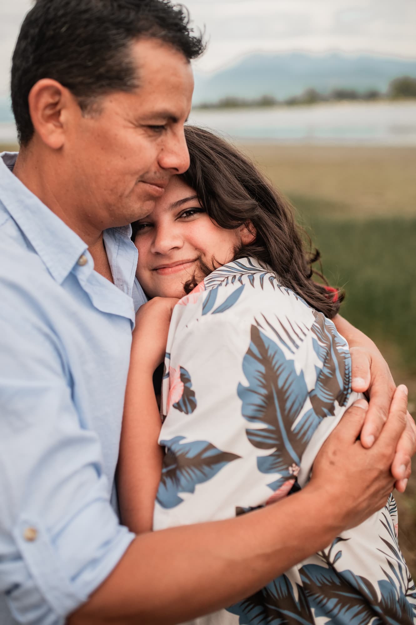Latino dad cradles his teenage daughter in photo session in Port Coquitlam.