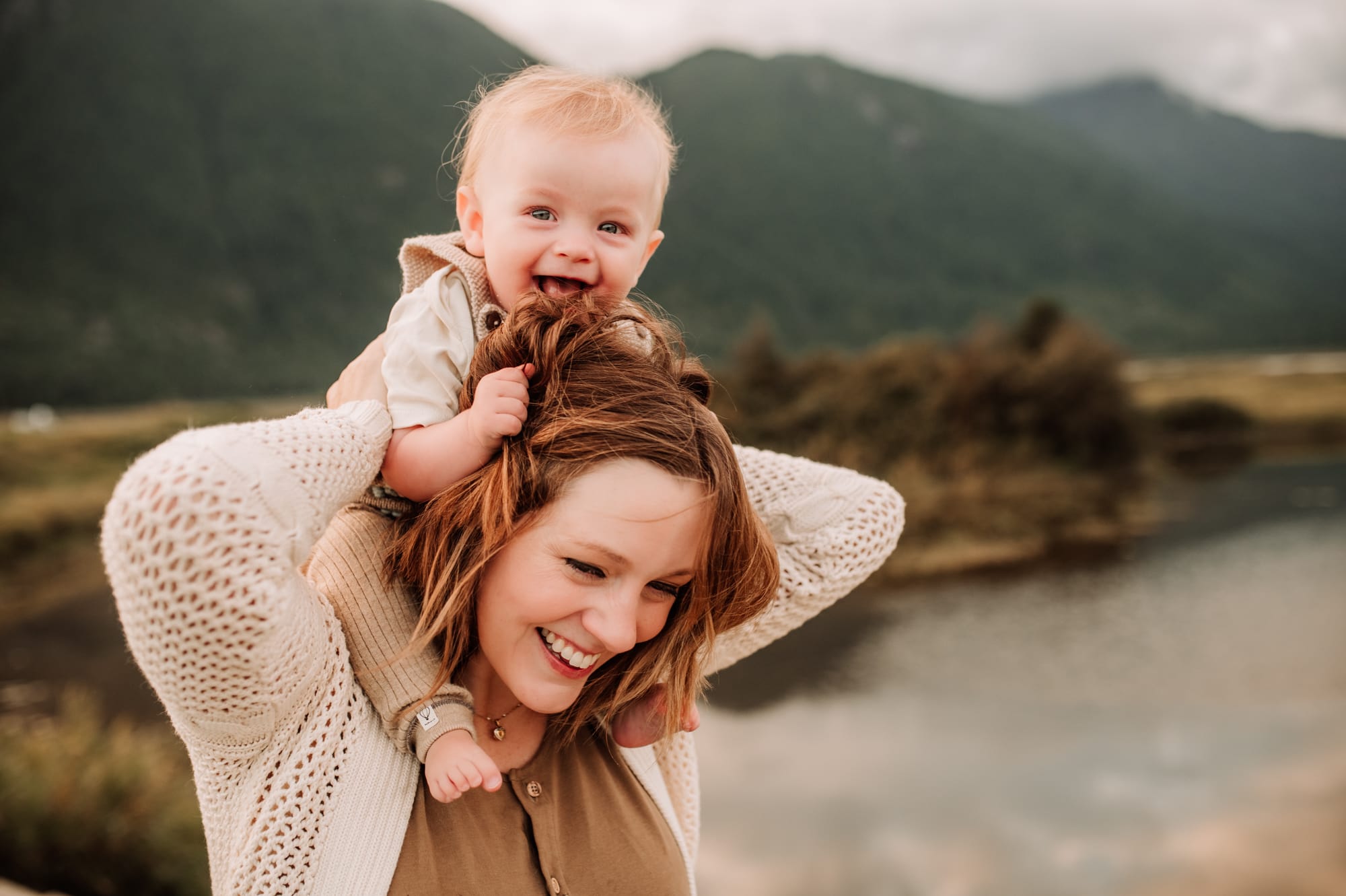 Baby boy grabs his mom's hair while she laughs during their family photo session in Pitt Lake.