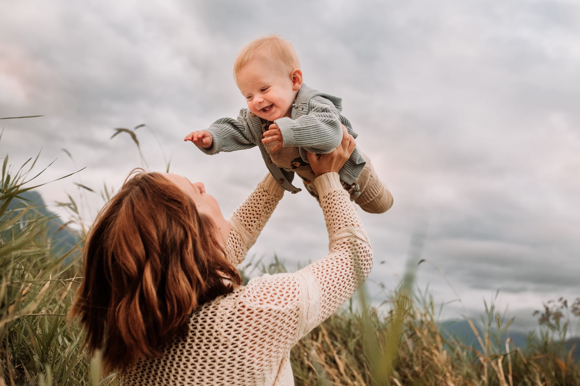 Mom lets her toddler boy fly high above her in Pitt Meadows family photo.