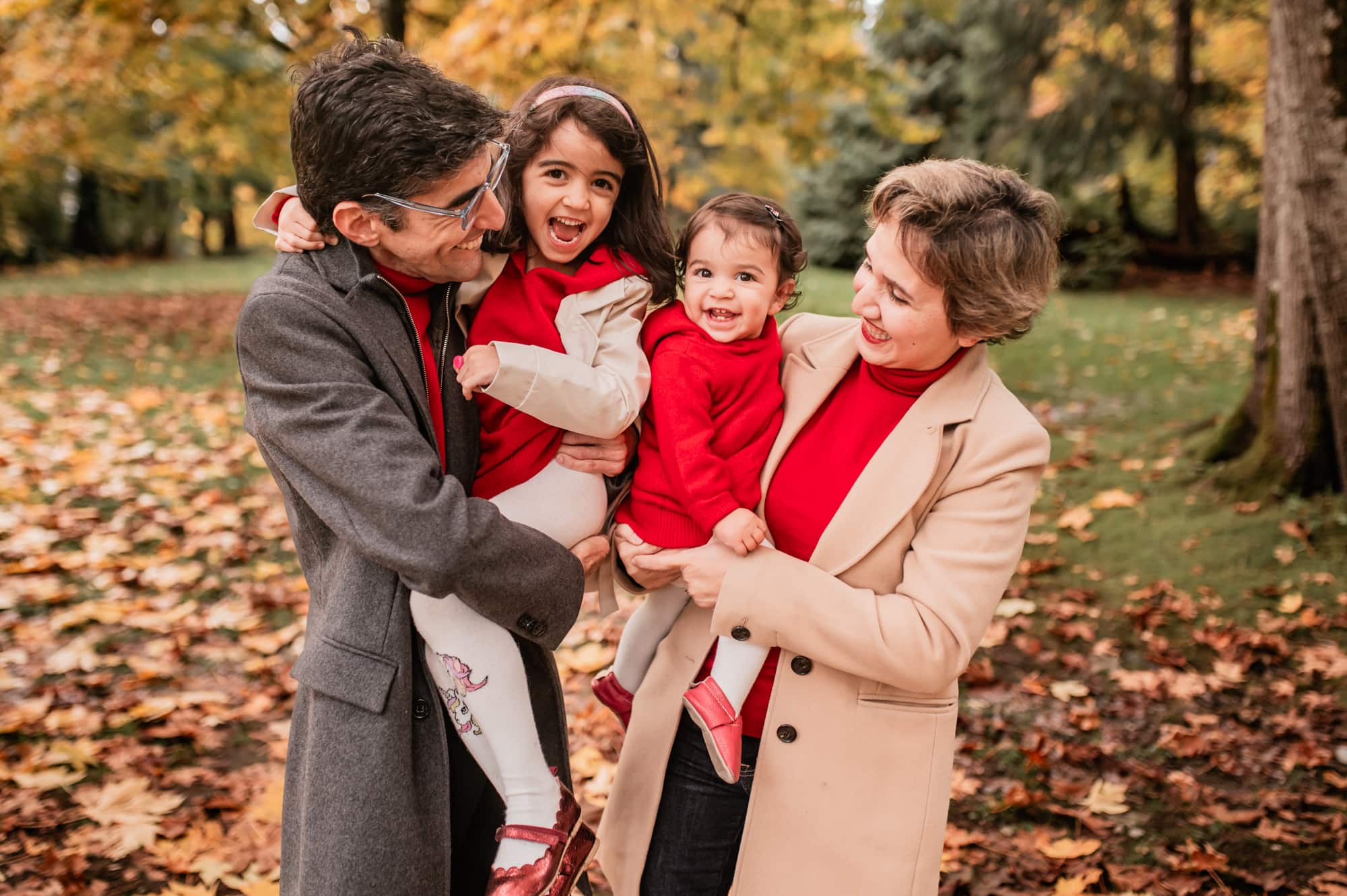 Family dressed in grey and red giggle in this fall family photo session in North Vancouver park.