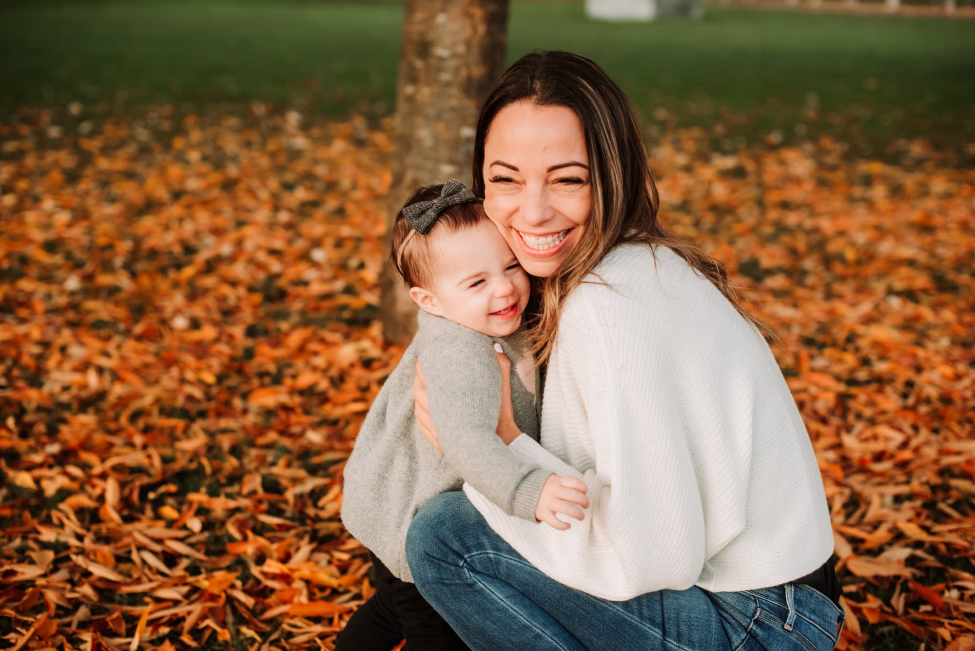 Vancouver Family Photographer captures mom and girl hugging in fall leaves in Vancouver.