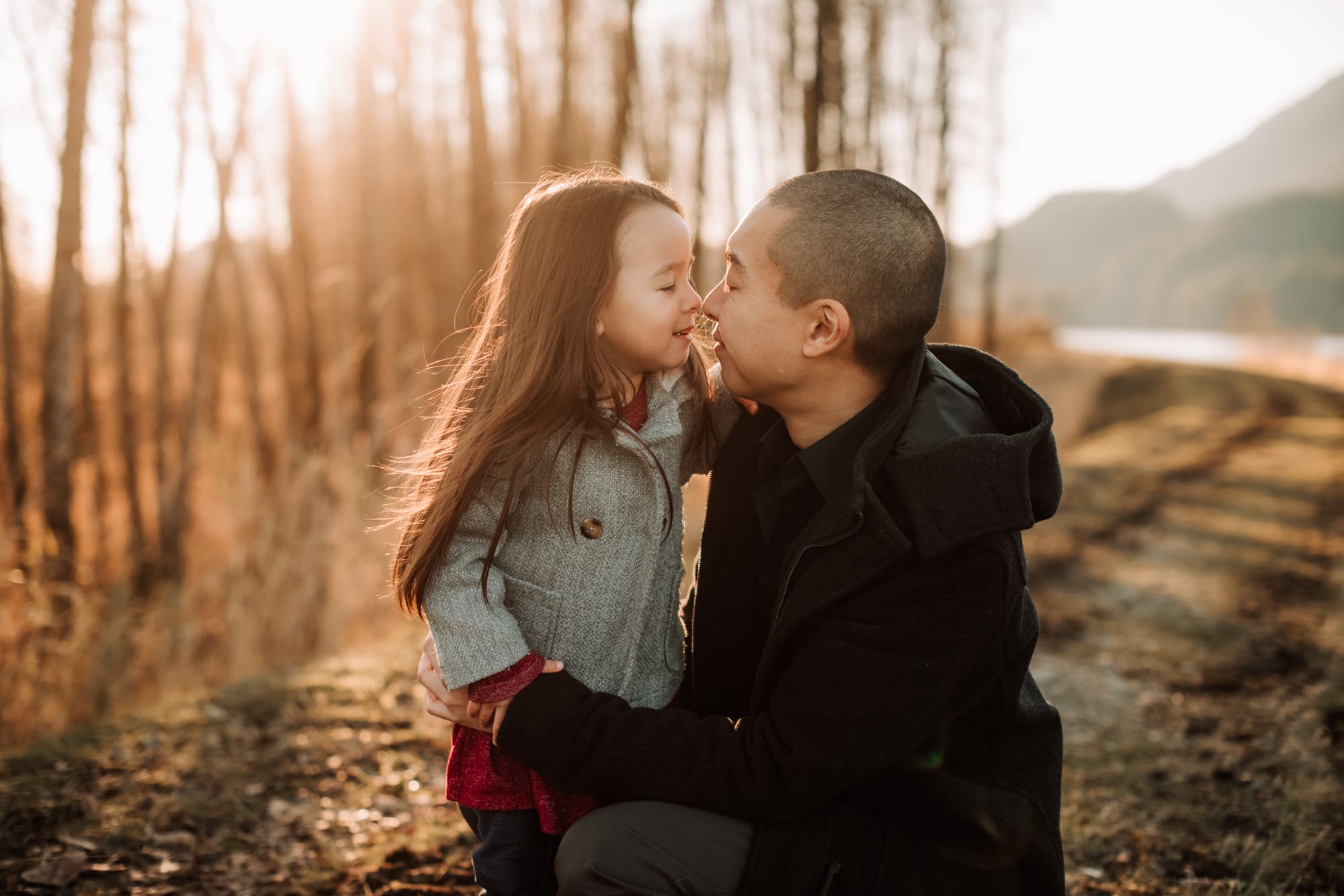 Vancouver Family Photographer shows girl and dad doing nose kisses at sunset